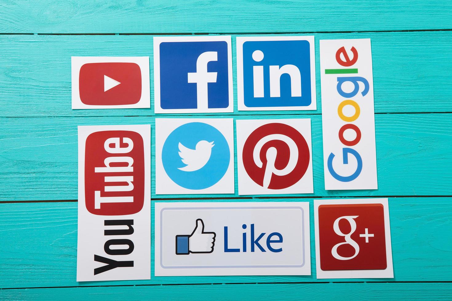 KIEV, UKRAINE - MARCH 10, 2017. Collection of popular social media logos printed on paper YouTube,Facebook, Twitter, Google Plus, Yahoo, Linkedin, Dropbox and like on blue wooden background. photo