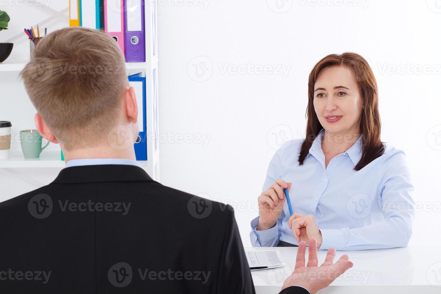 el hombre es entrevistado en el fondo de la oficina. empresaria y hombre de negocios tienen reunión y conversación. copia espacio y maqueta. enfoque selectivo foto