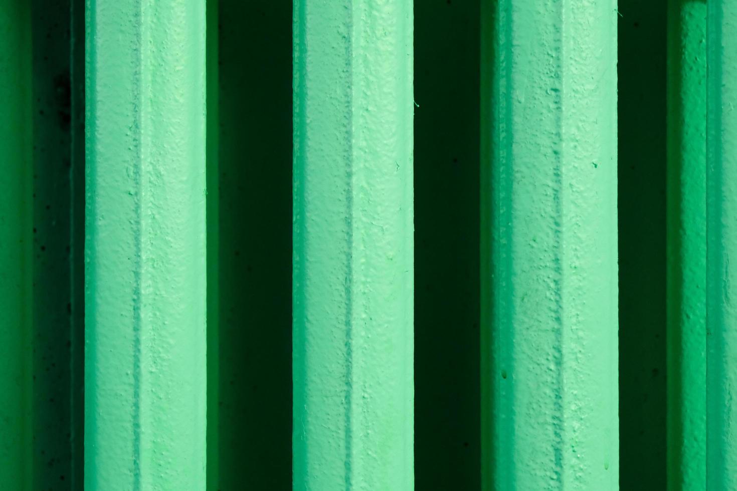 abstract vertical stripes pattern from an old home heating battery made of cast iron and painted in green photo