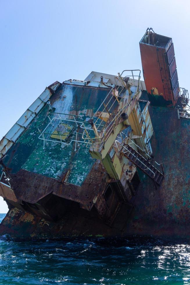 A sunken ship on the water surface of the sea. photo