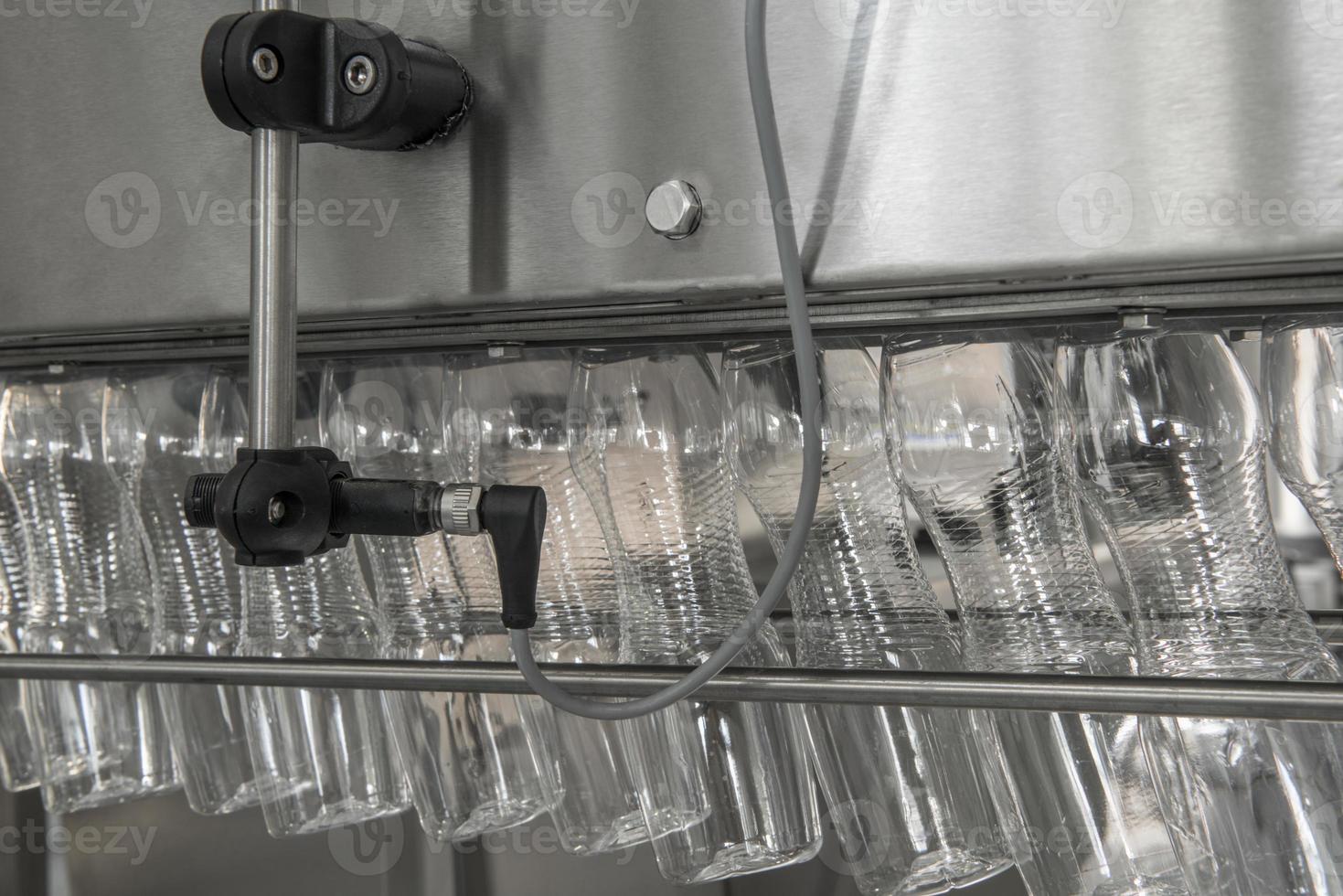 empty plastic bottles on conveyor belt. equipment at the dairy plant photo