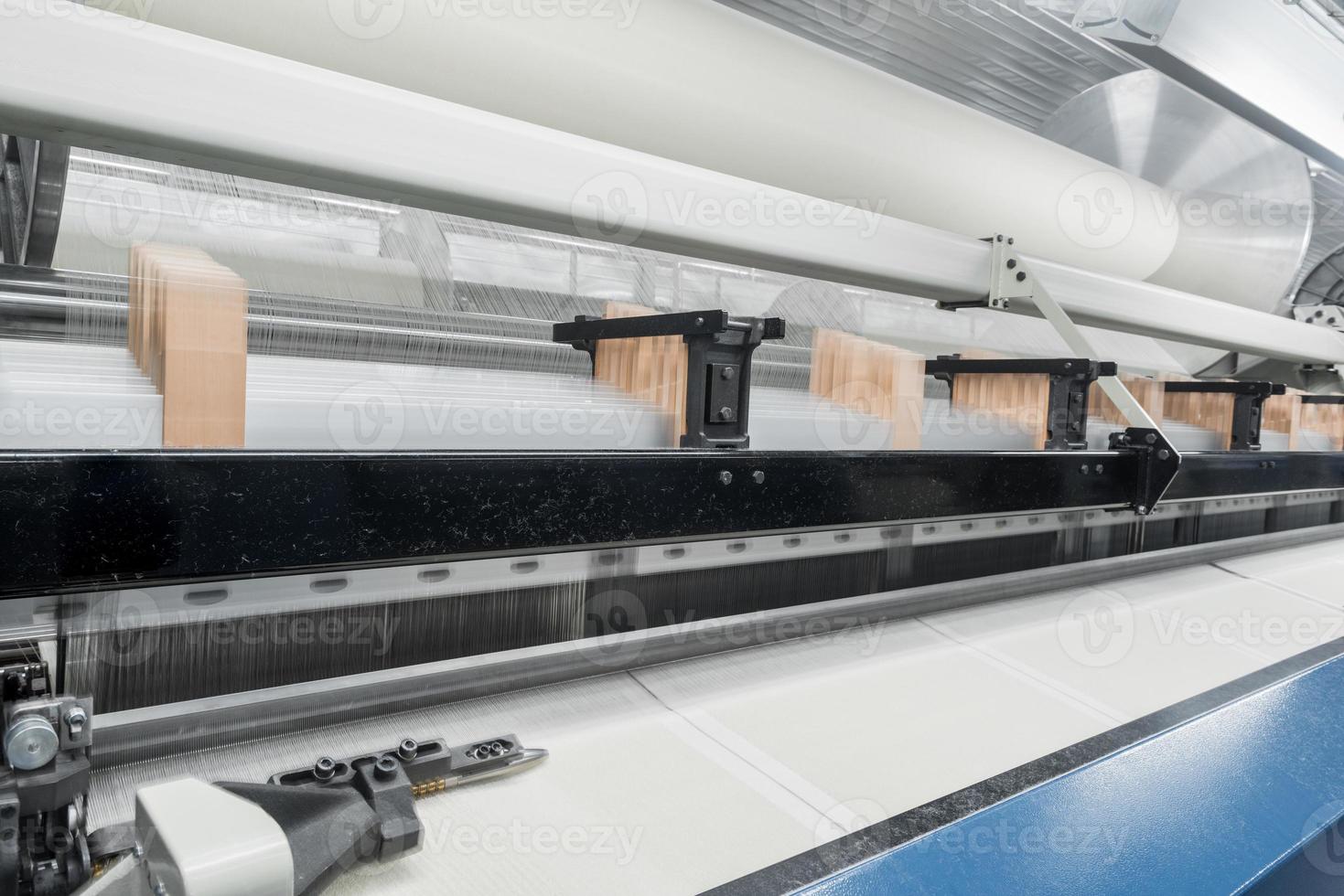 weaving loom at a textile factory, closeup. industrial fabric production line photo