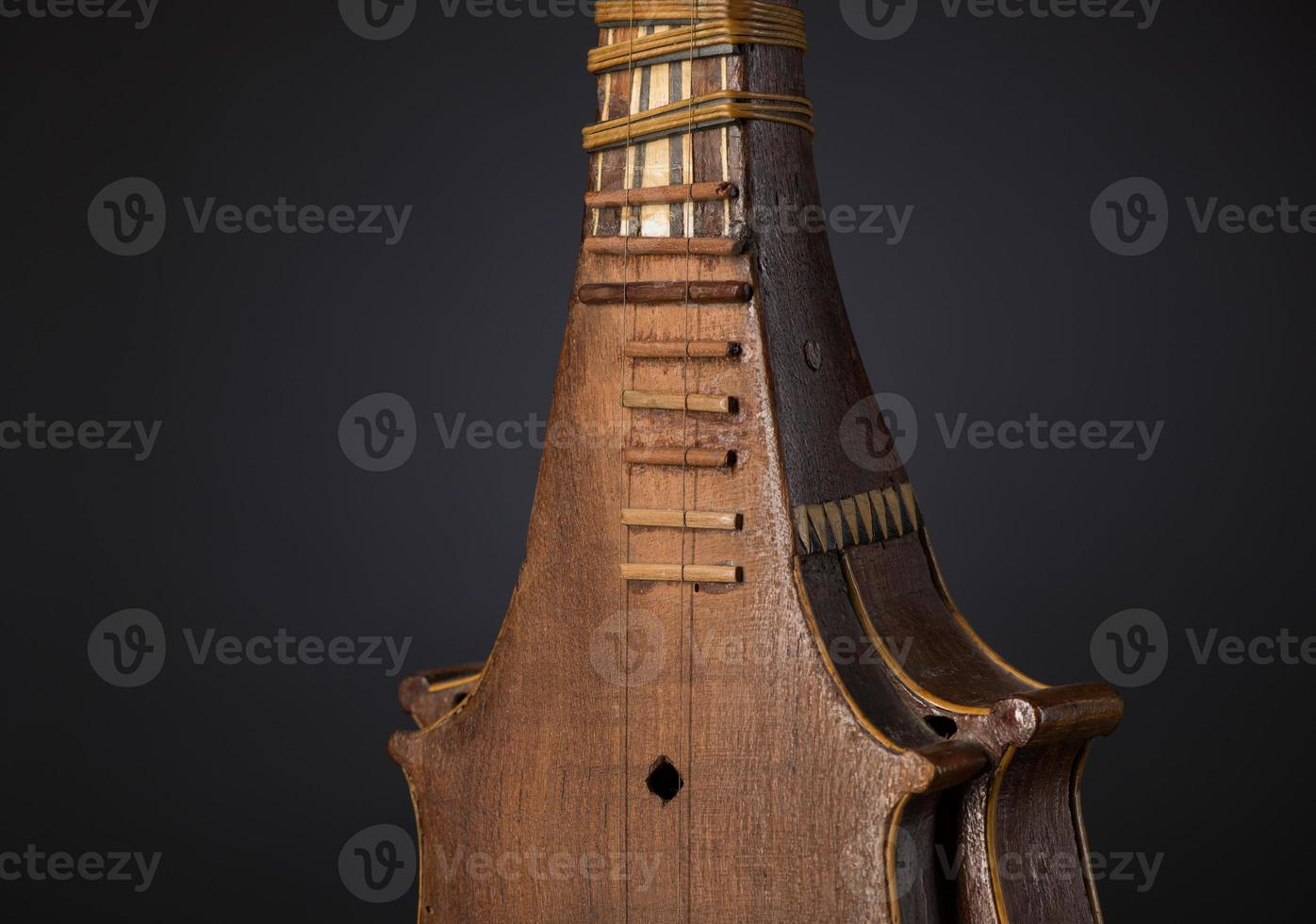 part ancient Asian stringed musical instrument on black background with backlight photo