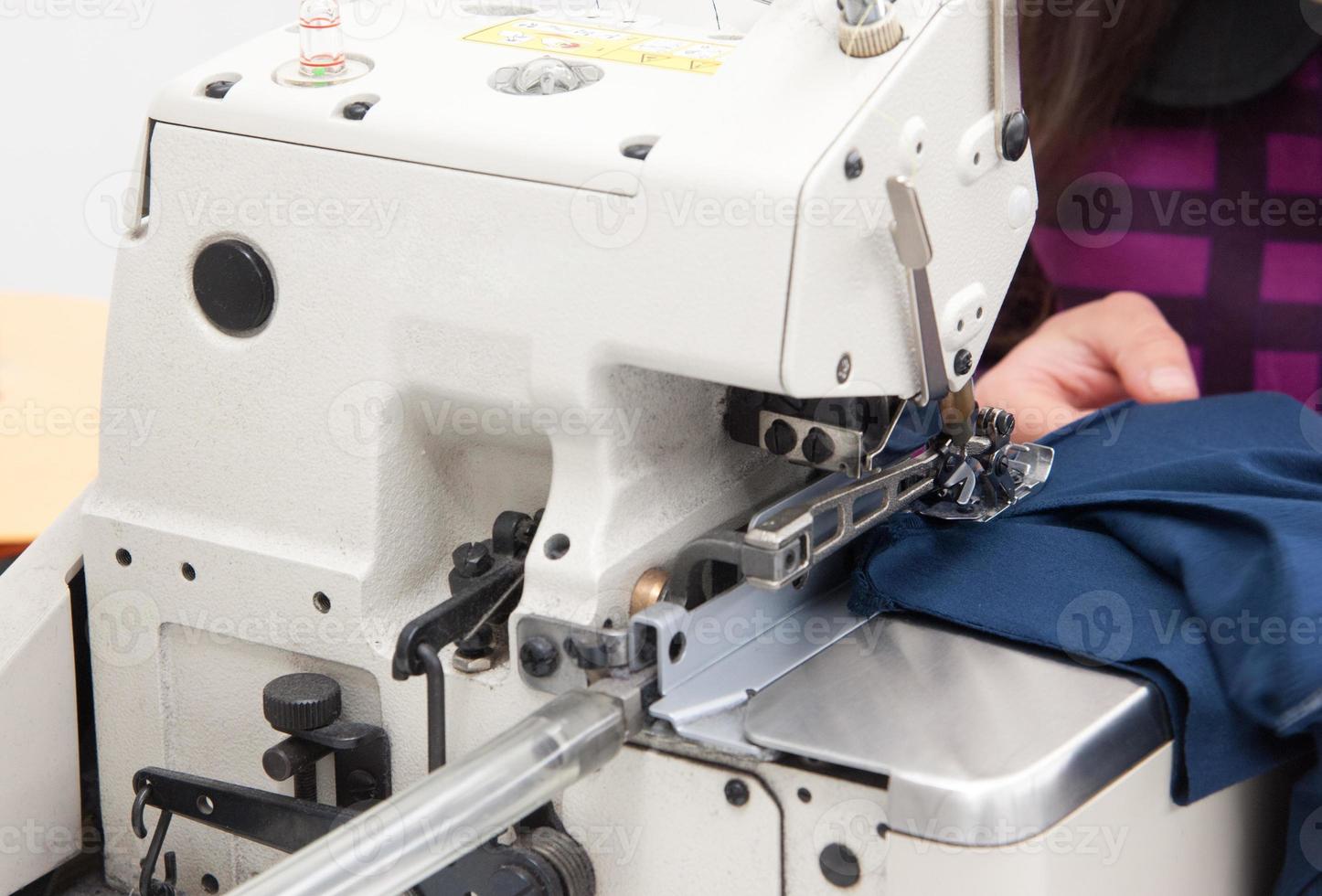 costurera en la máquina cose ropa en una fábrica de prendas de vestir foto