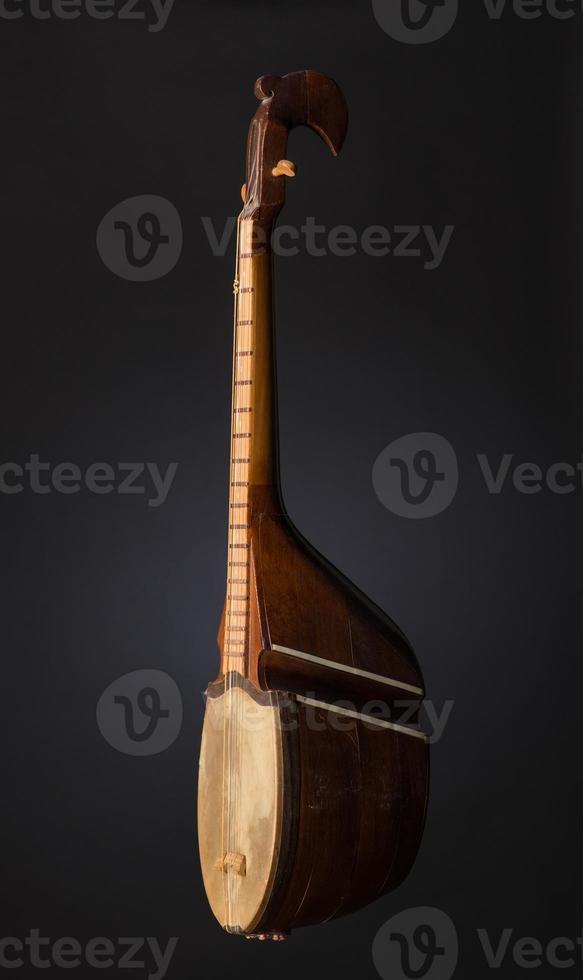 ancient Asian stringed musical instrument on black background with backlight photo