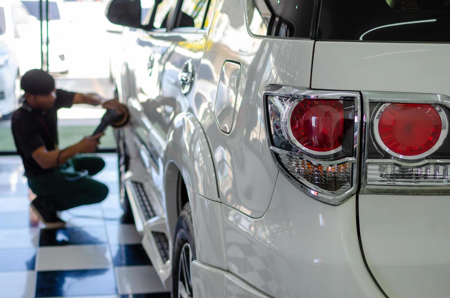 Man hands holding the work tool polish the car.Buffing and polishing car and wax. Car detailing.focus car lights photo