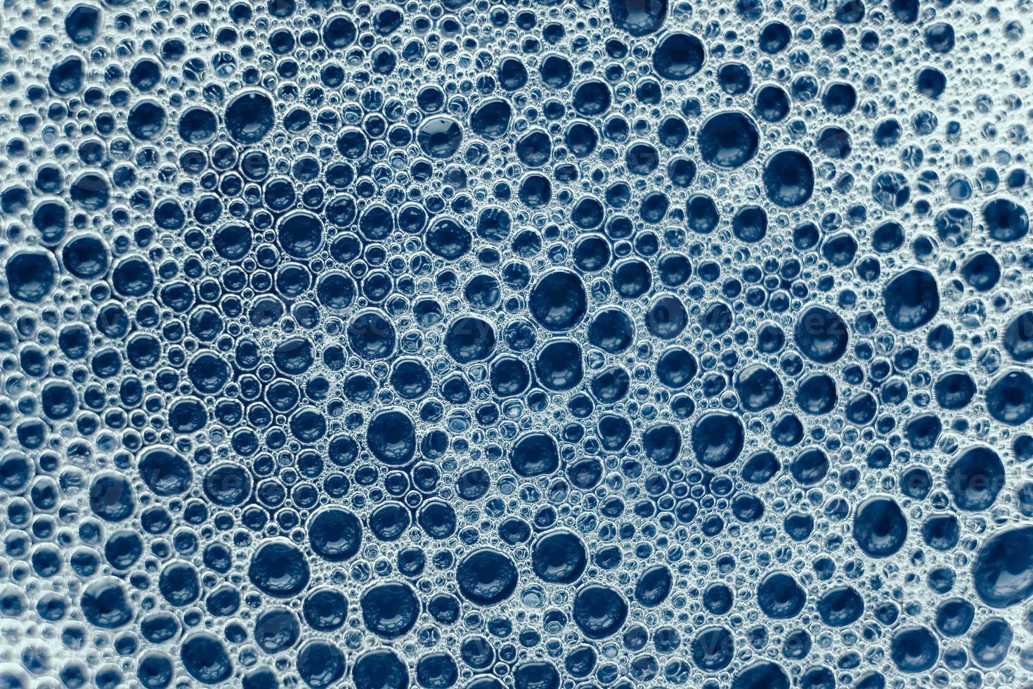 Soap bubbles on a background of blue water as a texture photo