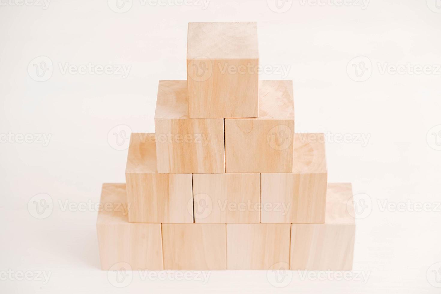 Pyramid of wooden blocks from natural wood on a white background. Copy, empty space for text photo