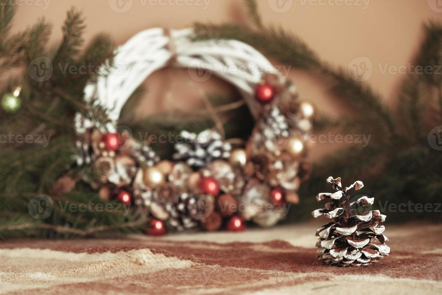 Pine cone on the background Christmas wreath of vines decorated with fir branches, Christmas balls and natural materials photo