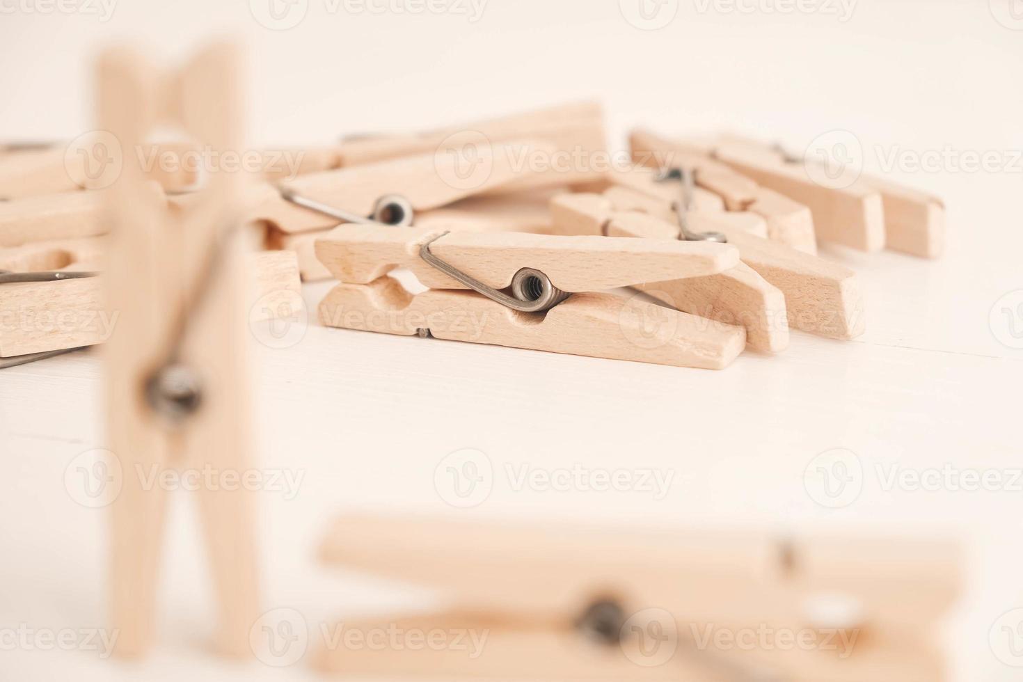 Many wooden clothespins on a white table background. Housework concept. Copy, empty space for text photo