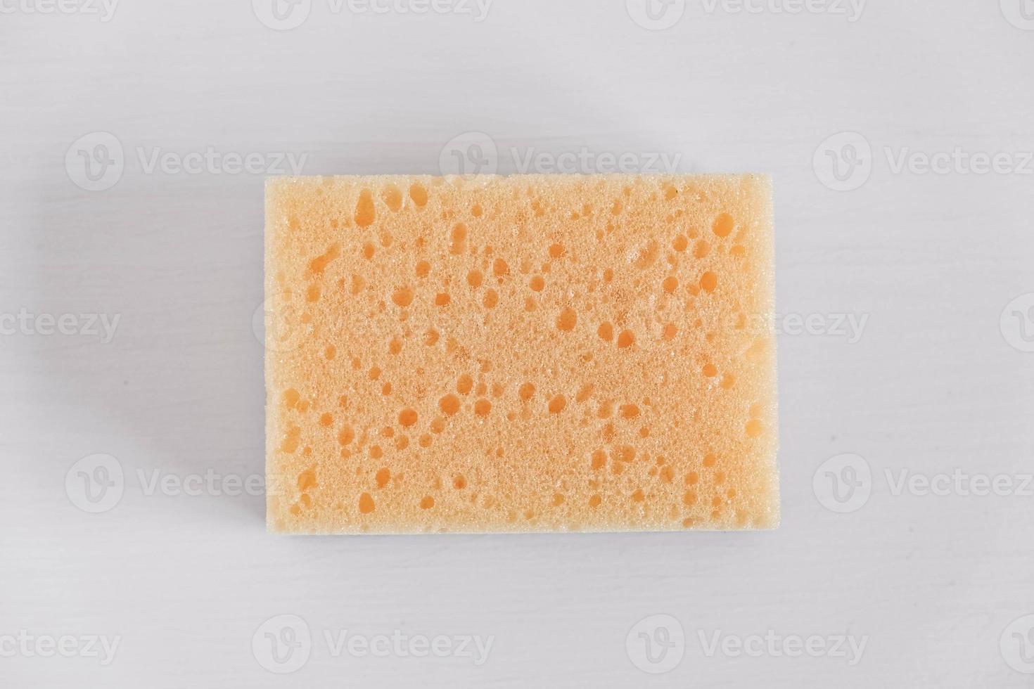 Yellow porous sponge on a white background photo