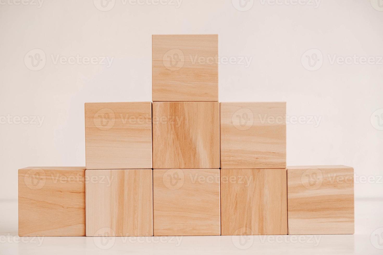 Pyramid of wooden blocks from natural wood on a white background. Copy, empty space for text photo