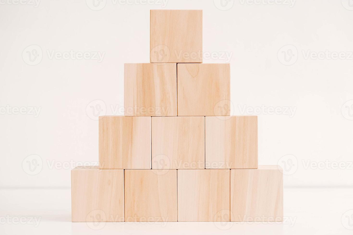 Pyramid of wooden blocks from natural wood on a white background. Copy, empty space for text photo