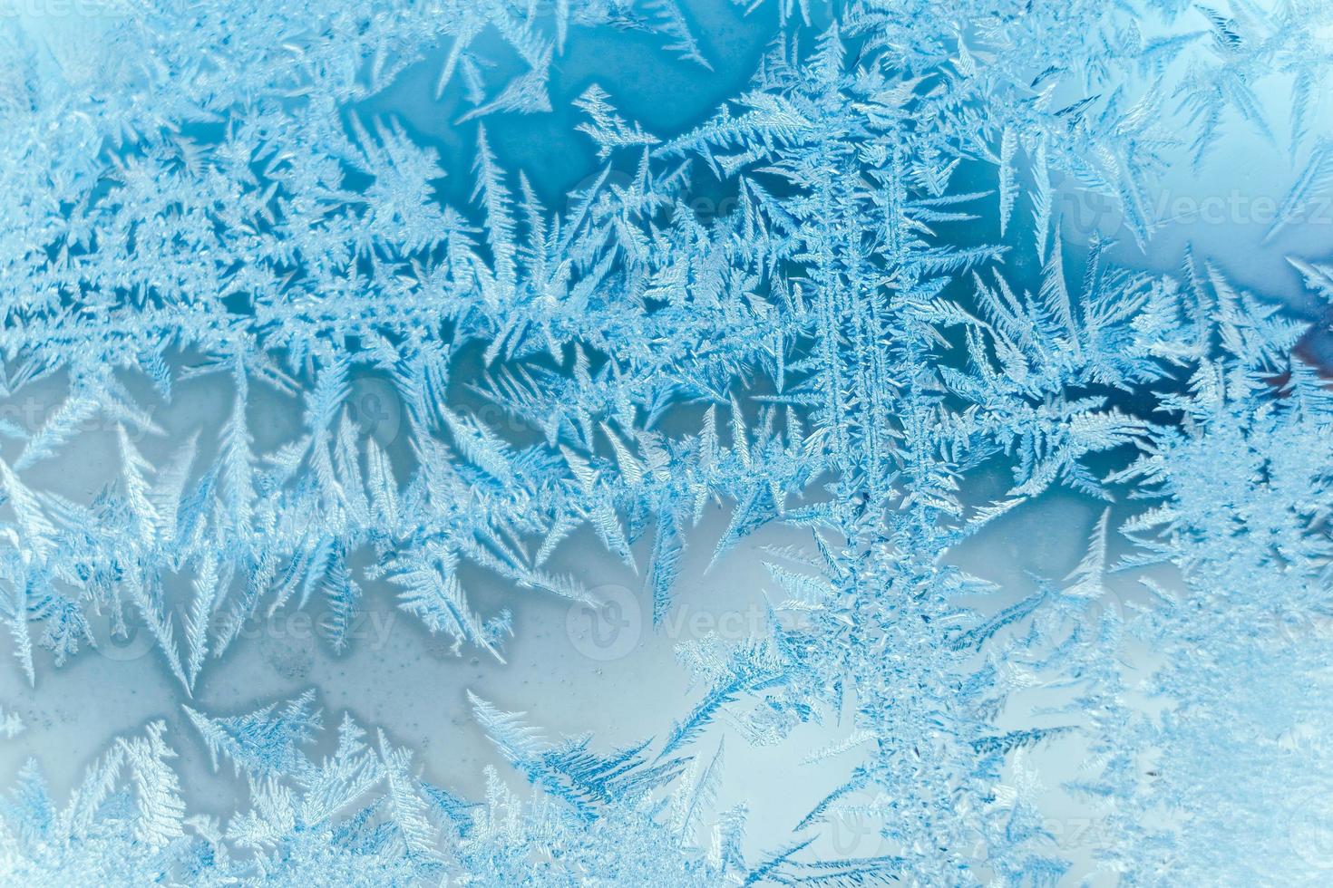 Ice patterns on frozen glass. Abstract ice pattern on winter glass as a background image photo
