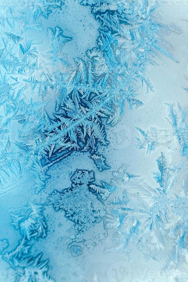 Ice patterns on frozen glass. Abstract ice pattern on winter glass as a background image. Copy, empty space for text photo