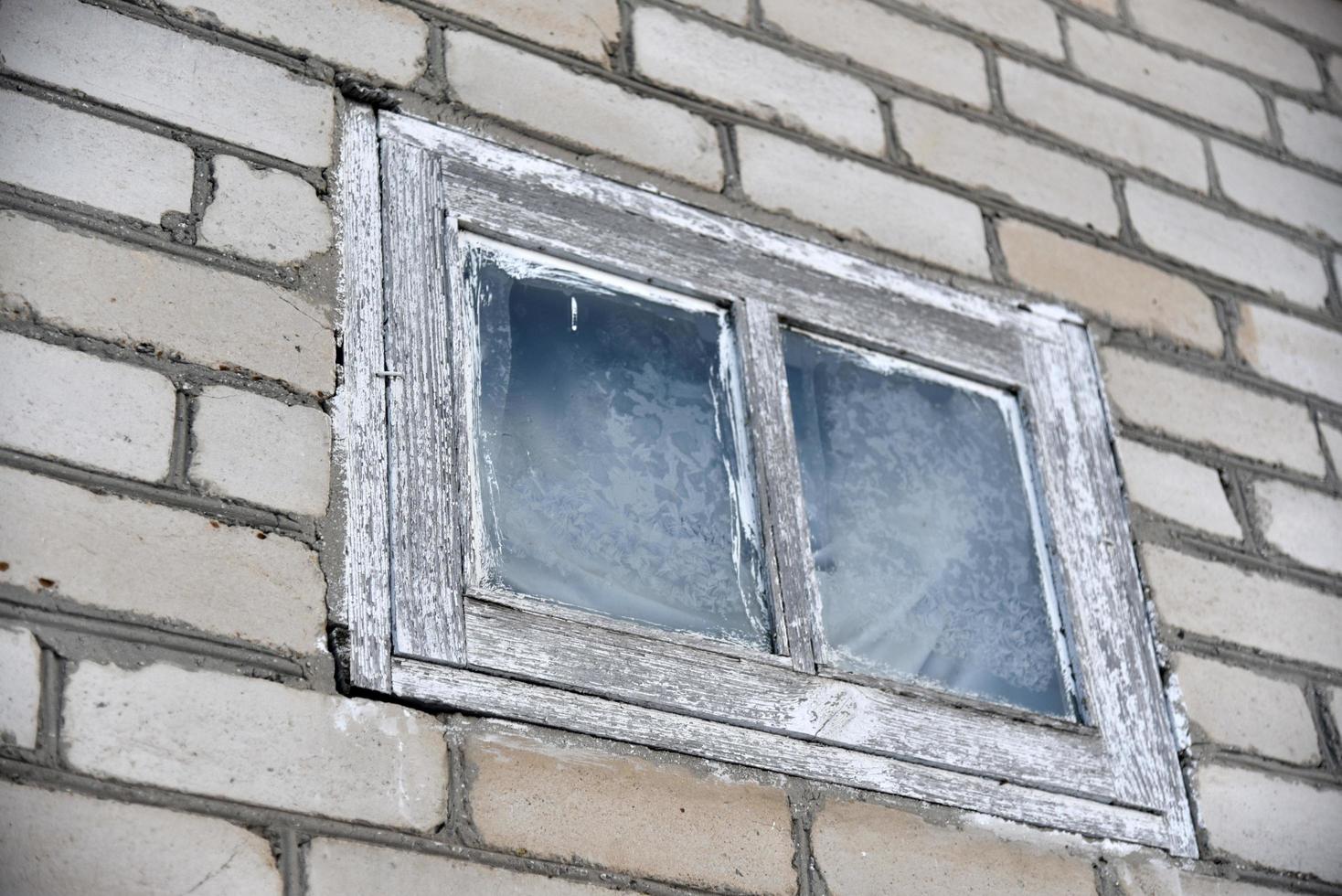 una pequeña ventana blanca en una pared de ladrillo foto