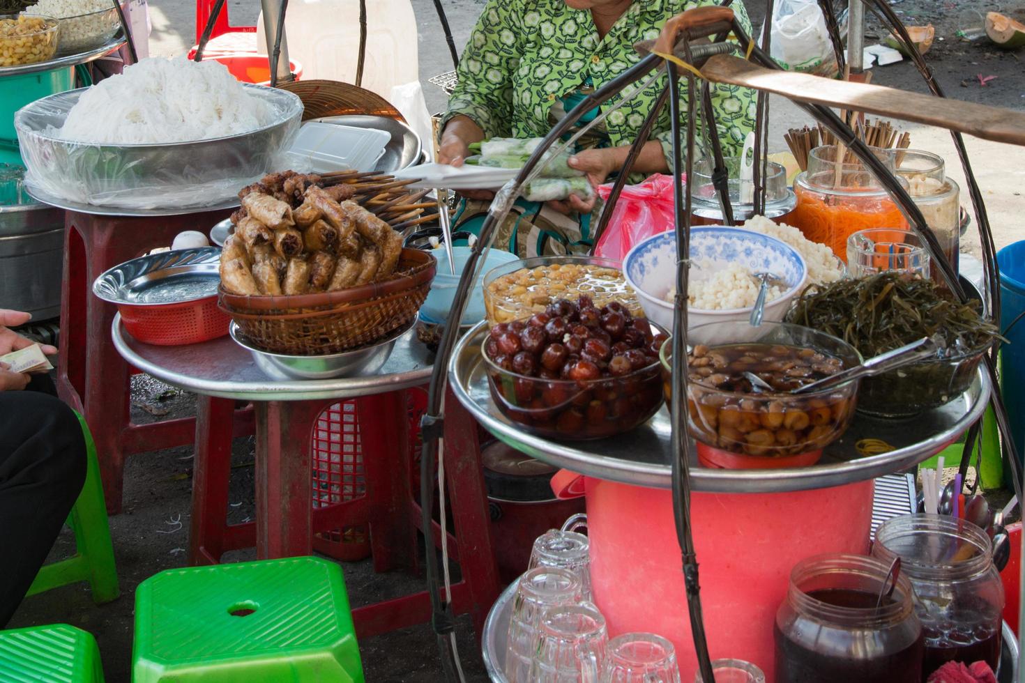 Street restaurant in Vietnam, where people can sit, have a drink and eat vietnamese rolls, meat sticks, vegetables,... photo