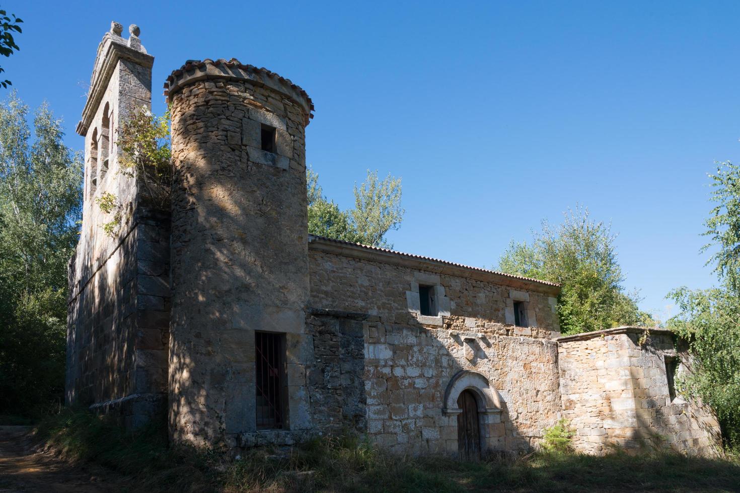 Beautiful view of a church with a stone round tower at Merindades, Burgos, Spain. Blue sky. photo