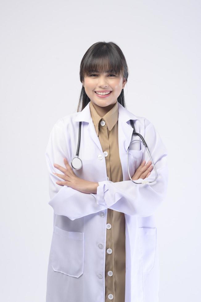 Young female doctor with stethoscope over white background photo