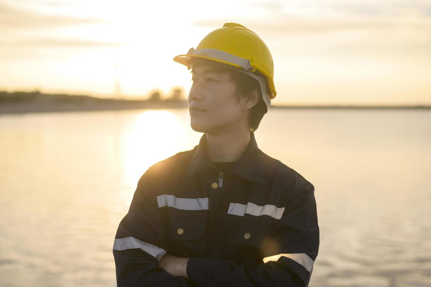 A male engineer wearing a protective helmet at sunset. photo