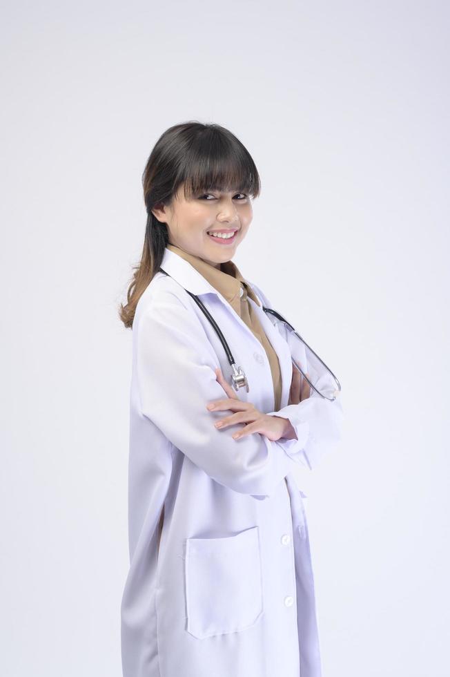 Young female doctor with stethoscope over white background photo