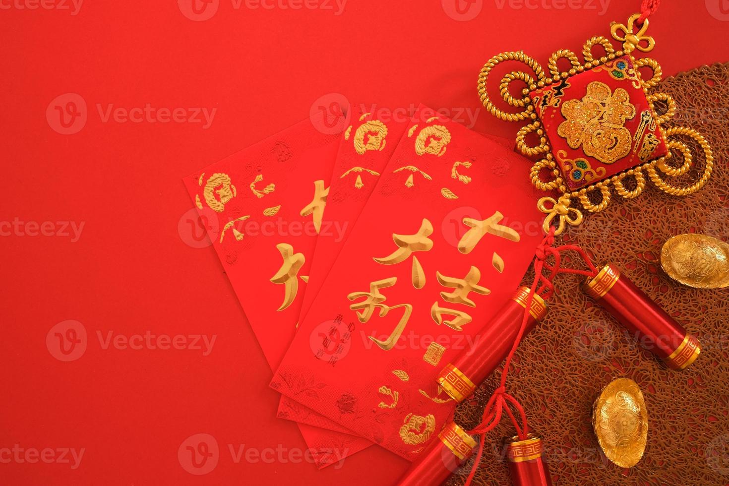 Chinese New Year festival concept. Red envelopes, and gold ingots on red background. Chinese character da ji da li meaning great luck great profit and fu which stands for luck.. photo
