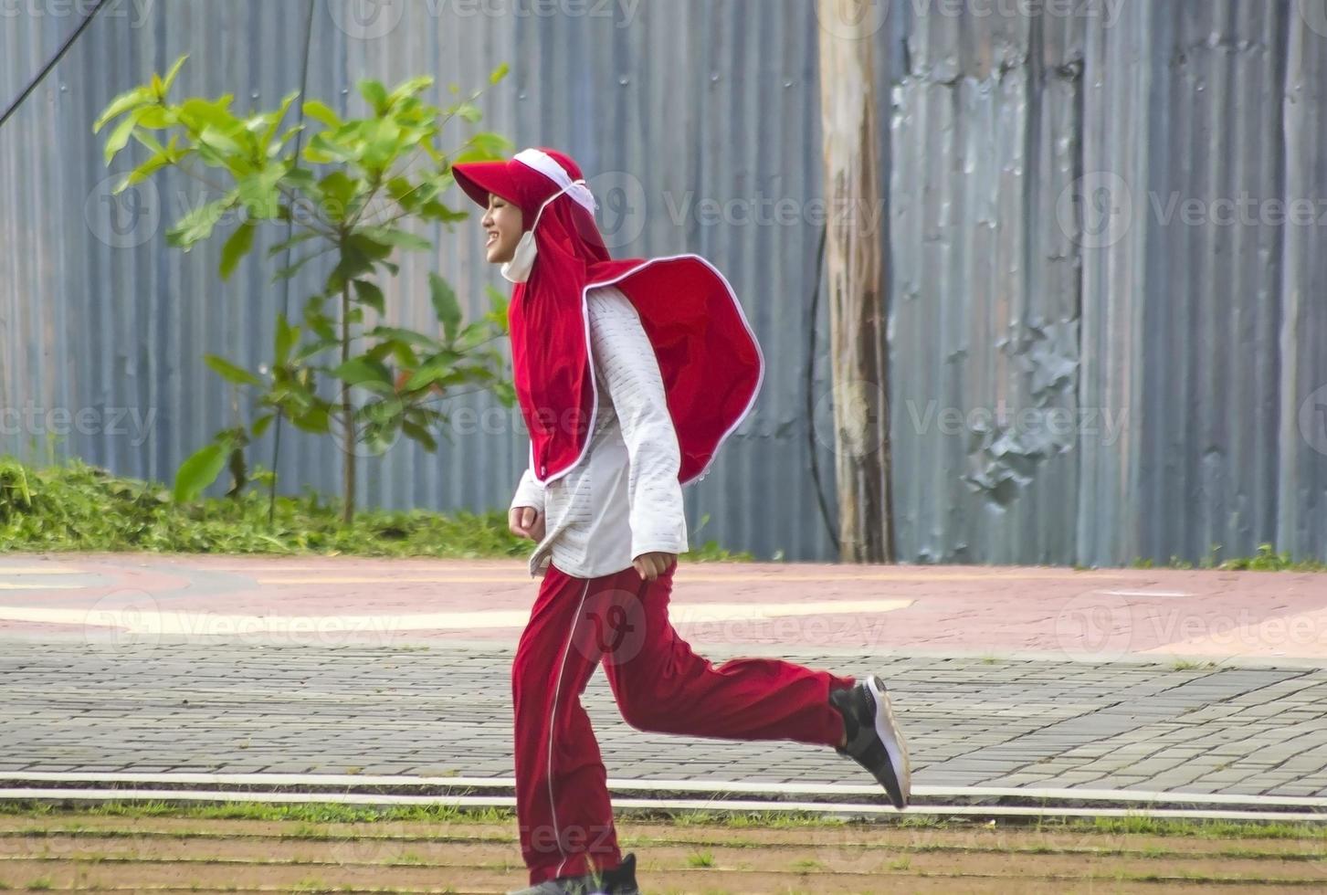 A muslim girl doing exercising at the public park photo