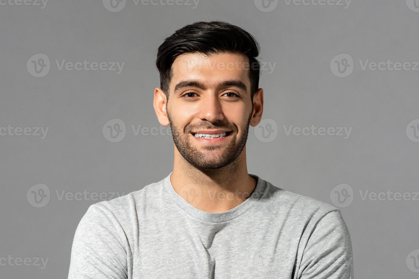 Close up portrait of happy handsome smiling young Caucasian man face with bristles on isolated light gray studio background photo