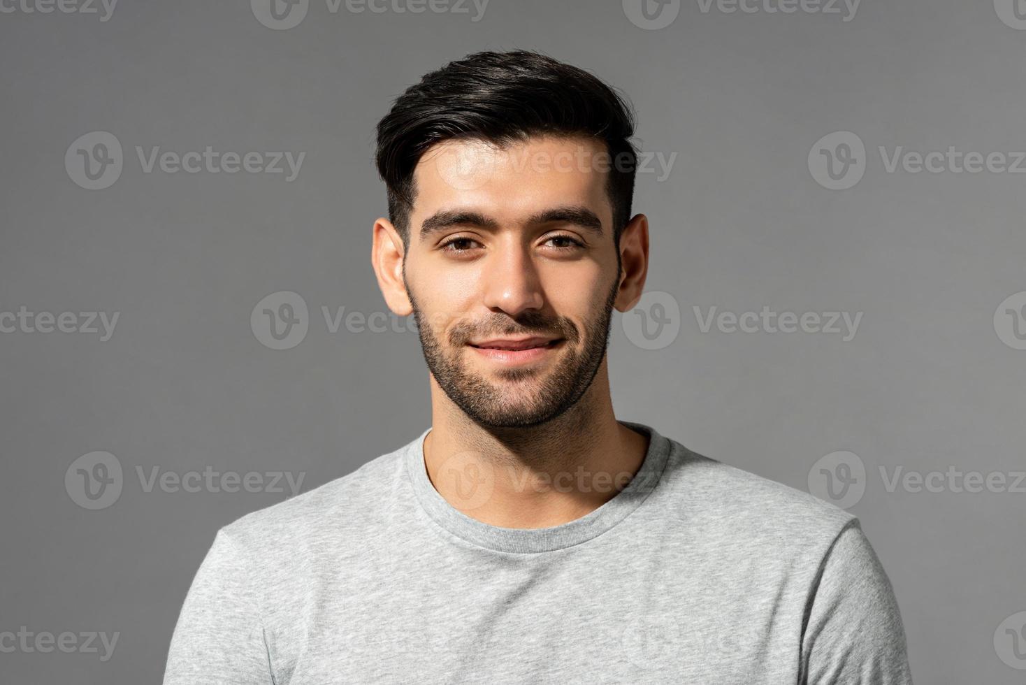 Close up portrait of smiling handsome young Caucasian man face looking at camera on isolated light gray studio background photo