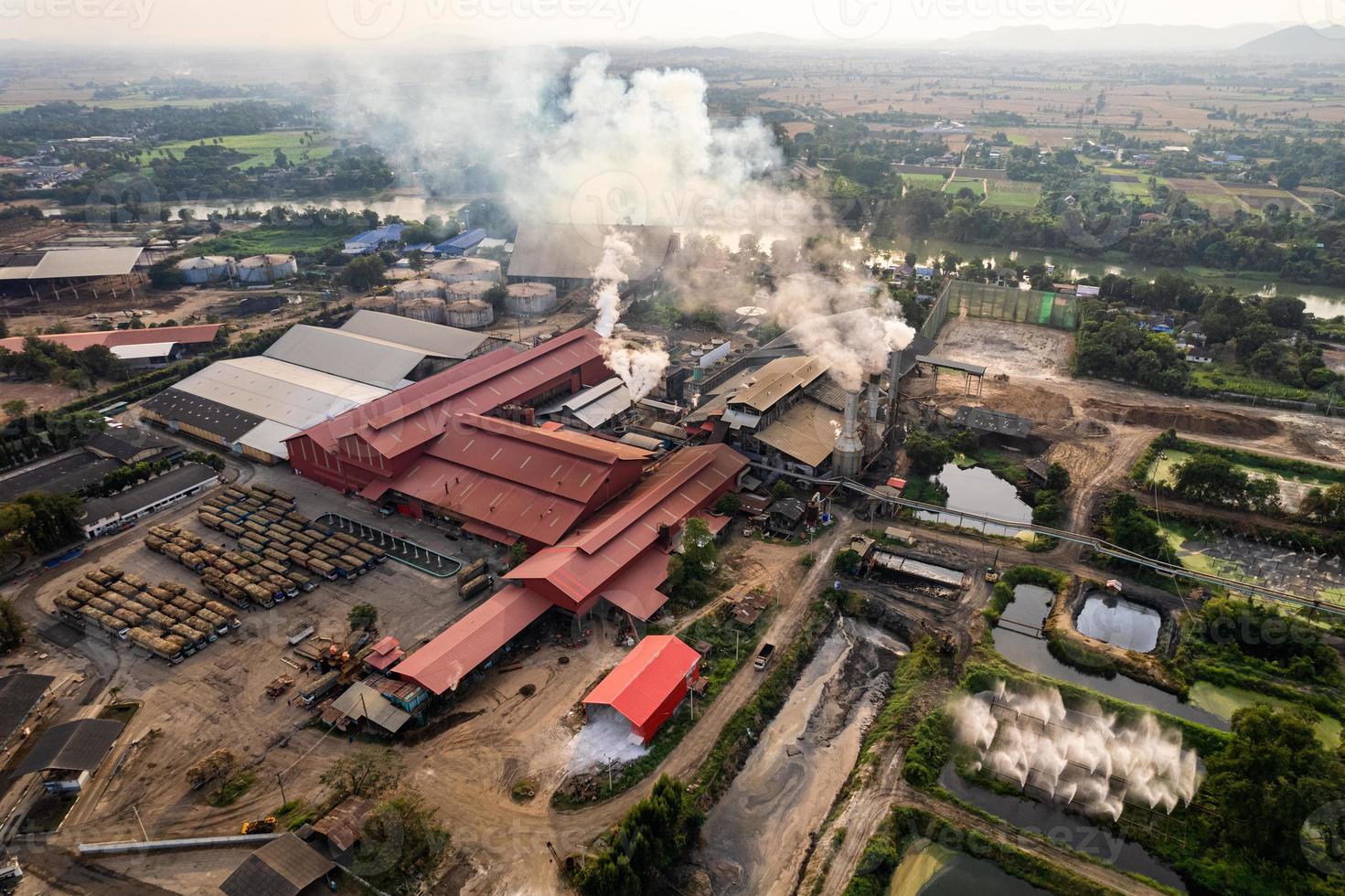 Sugar bioethanol translation factory working with steam from the chimney and sugarcane truck photo