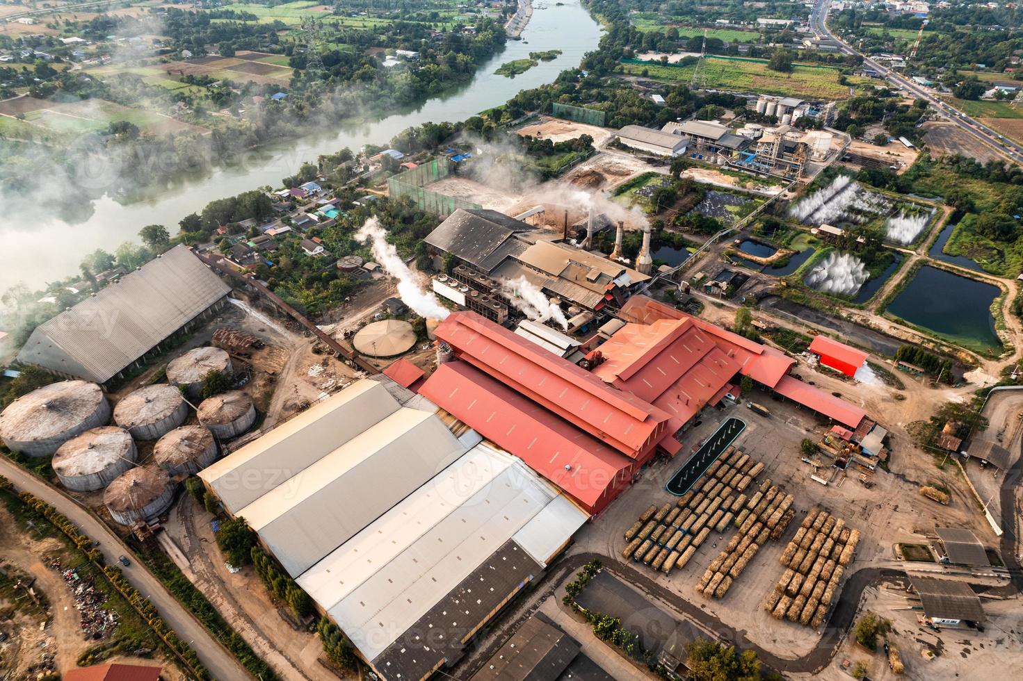 Sugar bioethanol translation factory working with steam from the chimney and sugarcane truck photo