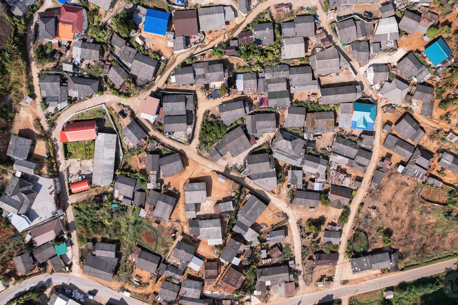 Top view of neighborhood traditional rural village of tribe local people on the hillside surrounded by forest in faraway photo