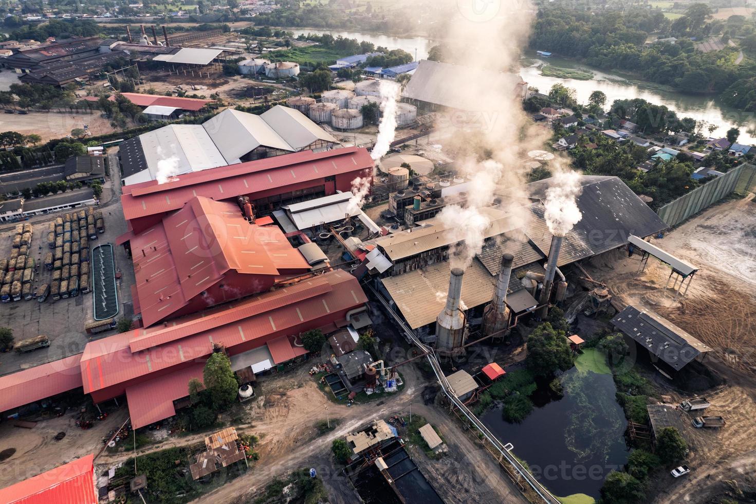 Sugar bioethanol translation factory working with steam from the chimney and sugarcane truck photo