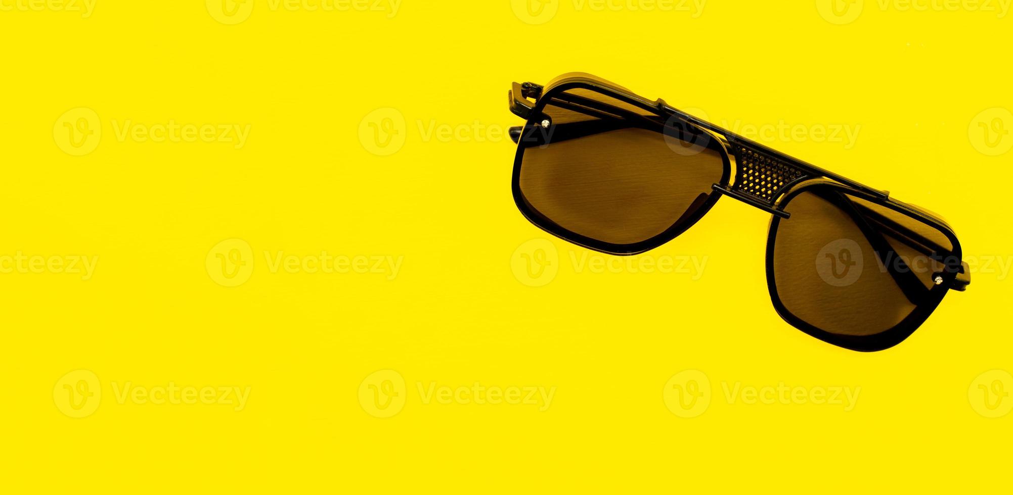 gafas de sol elegantes aisladas en un fondo amarillo con un espacio en blanco para el texto foto