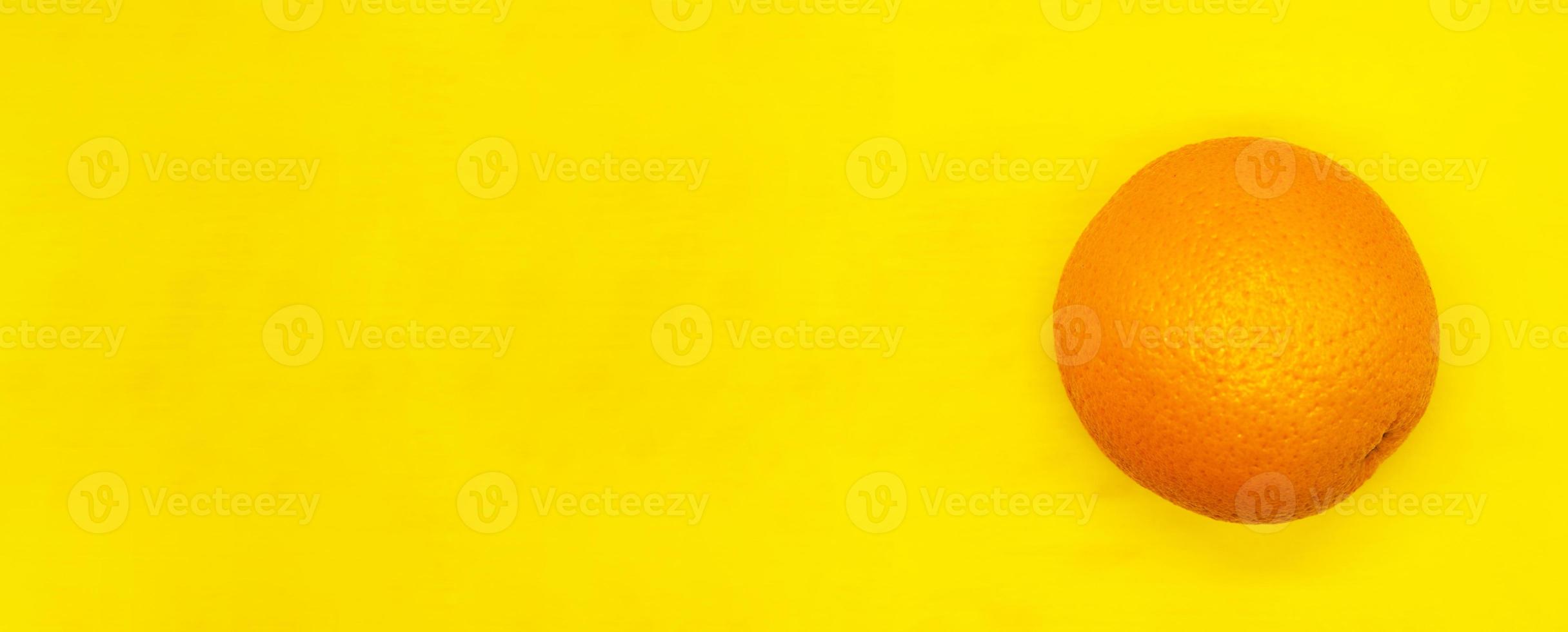 juicy ripe orange isolated on a yellow background close up with a blank space for your text photo