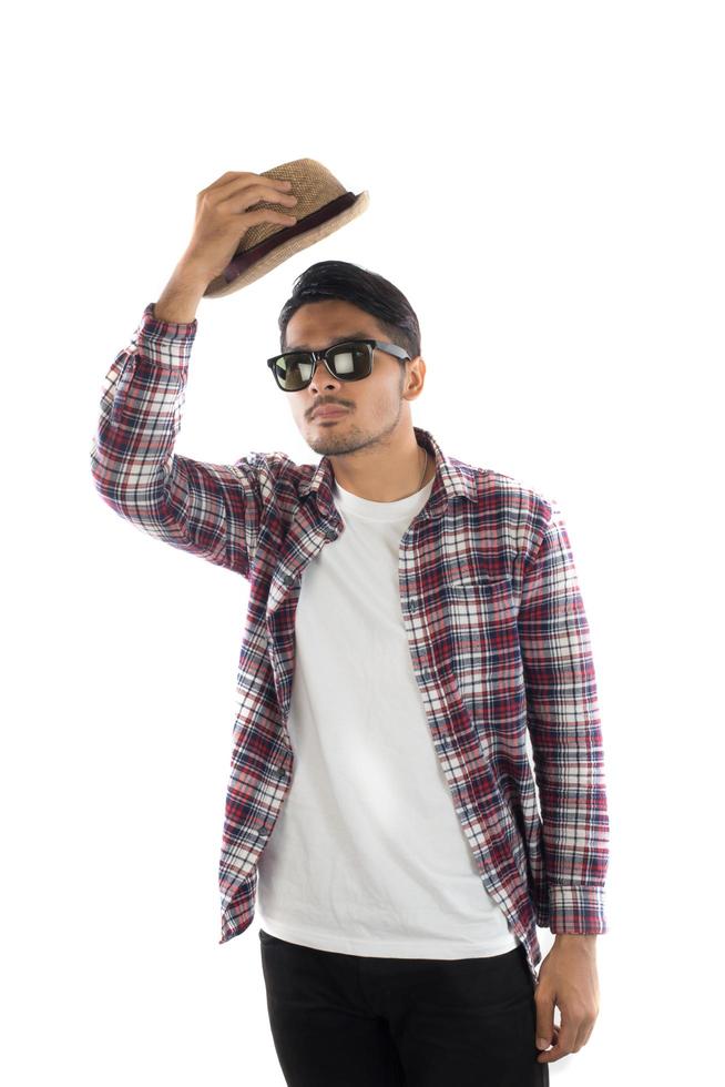 retrato de un joven hipster ajustando el sombrero con la cabeza en la cámara aislada sobre el fondo blanco del estudio. foto