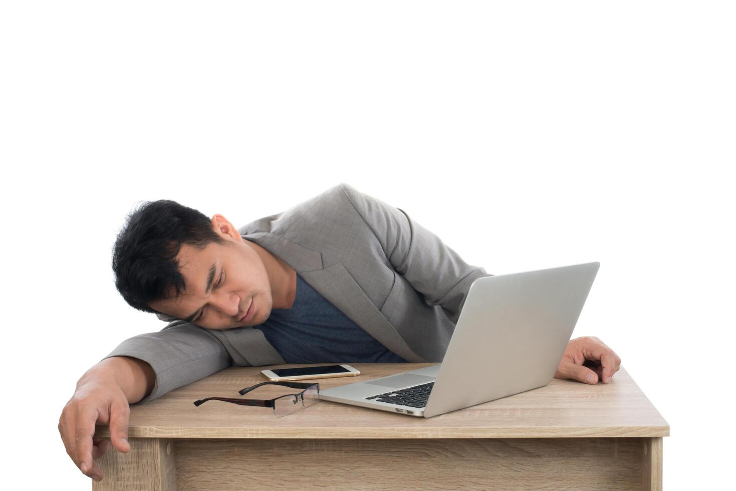 Businessman sleeping next to his laptop computer with white background. photo