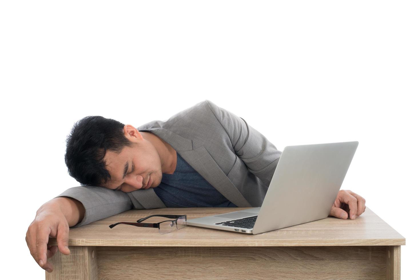 Businessman sleeping next to his laptop computer with white background. photo