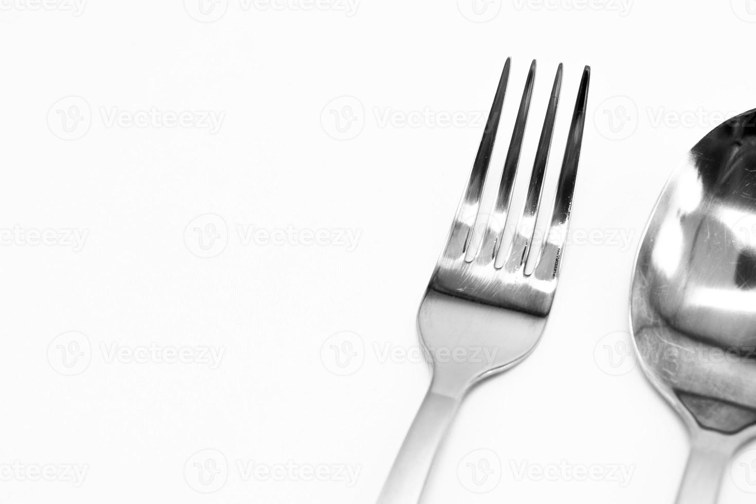 un juego de cubiertos de un tenedor, una cuchara sobre un fondo blanco. foto