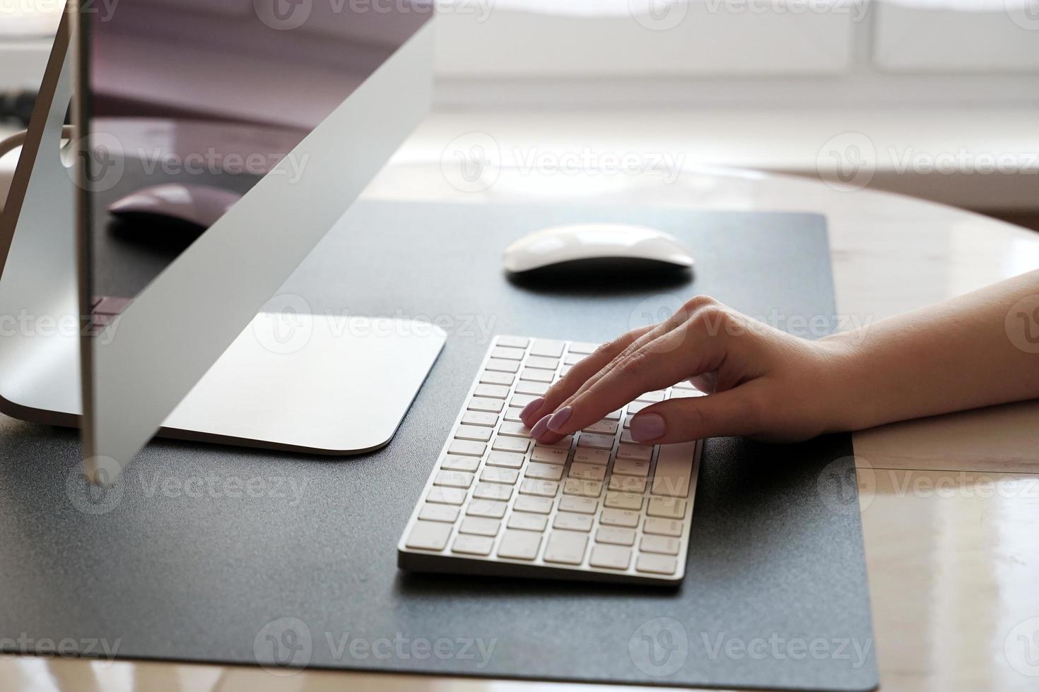 Work at home. Typing on the keyboard. Working at the computer remotely of a young girl. photo