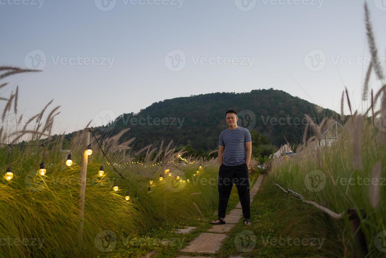 Portrait of Man Standing in Meadow Field at Sunset photo