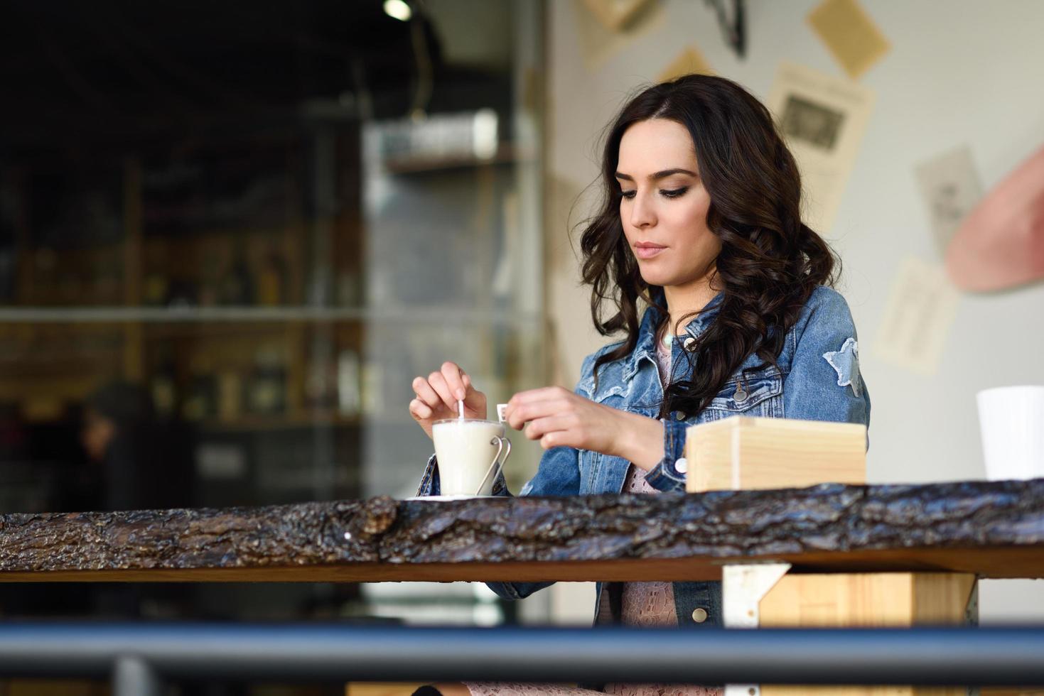 mujer sentada en el interior de un café urbano con ropa informal foto
