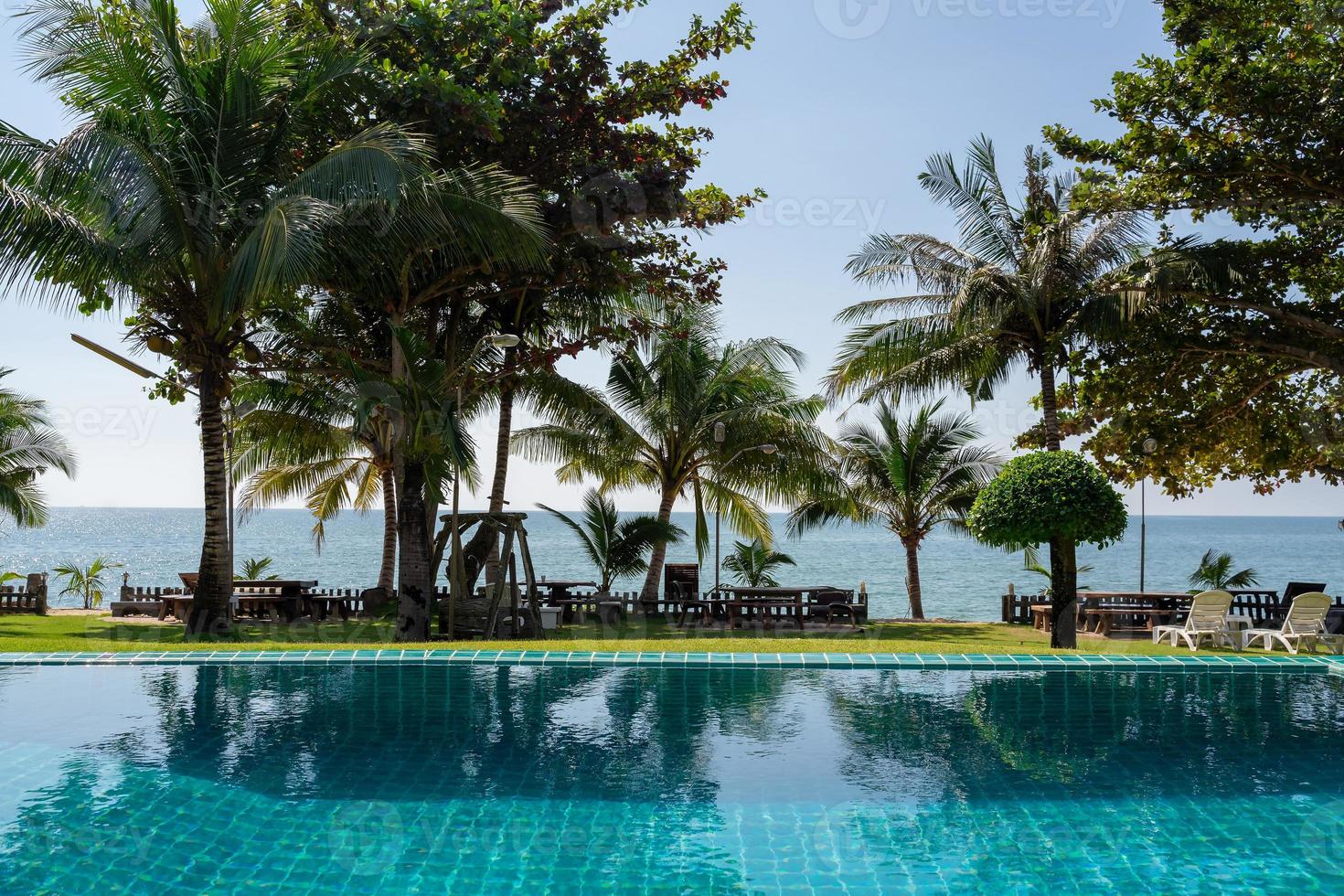 Part of swimming pool with background of tropical sea. photo