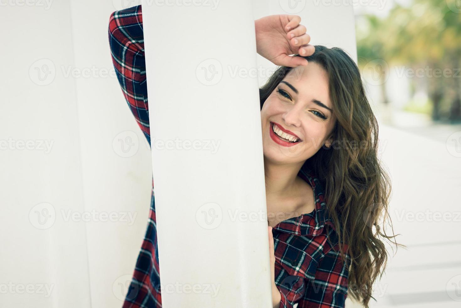 mujer joven con hermosos ojos azules sonriendo en el fondo urbano foto