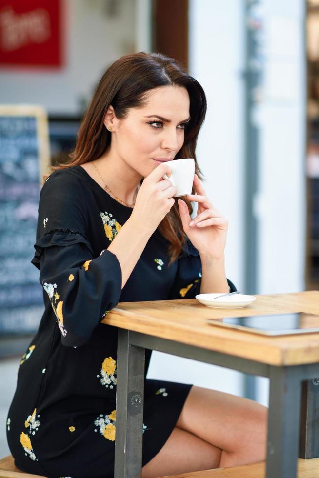 Middle-aged woman drinking coffee in an urban cafe bar. photo