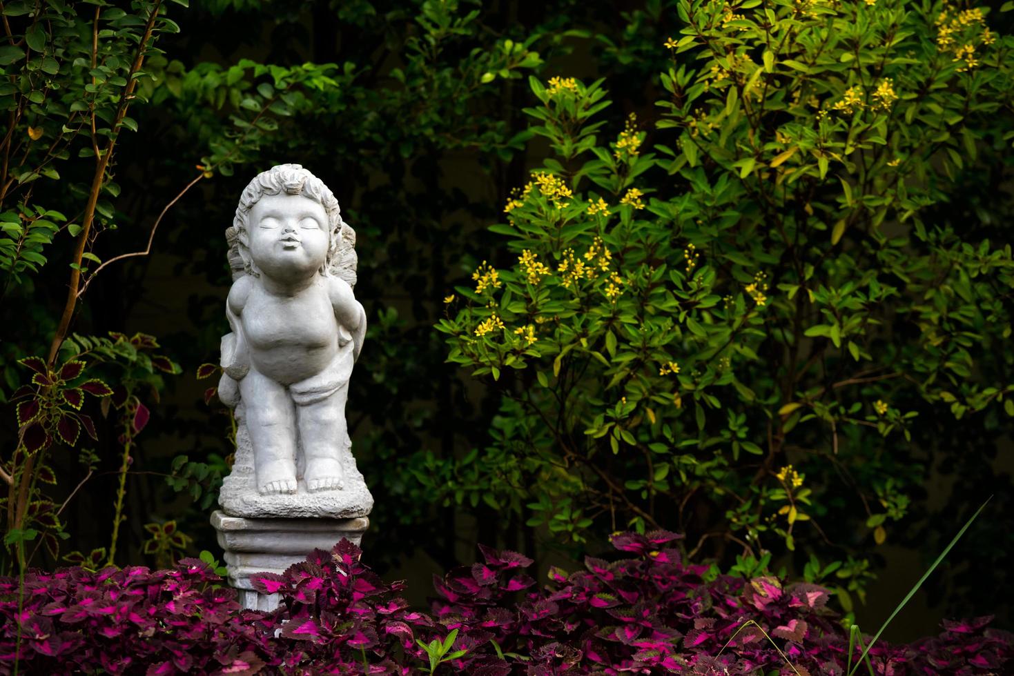 figurilla blanca de un ángel de pie y besándose en la casa del jardín el día foto