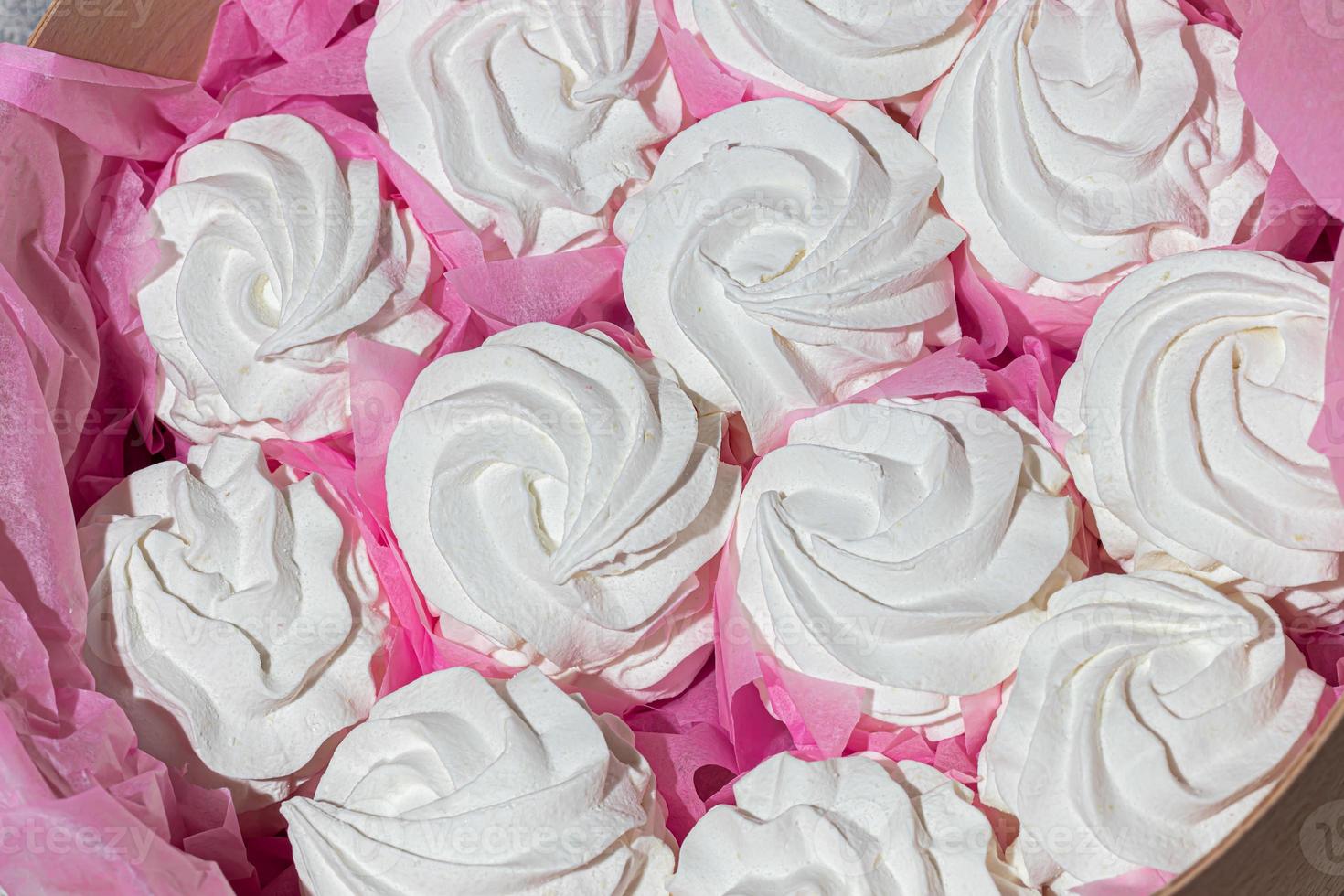 Handmade marshmallows in wooden packages on a light background with flowers. The concept of the holidays Women's Day and Valentine's Day. photo