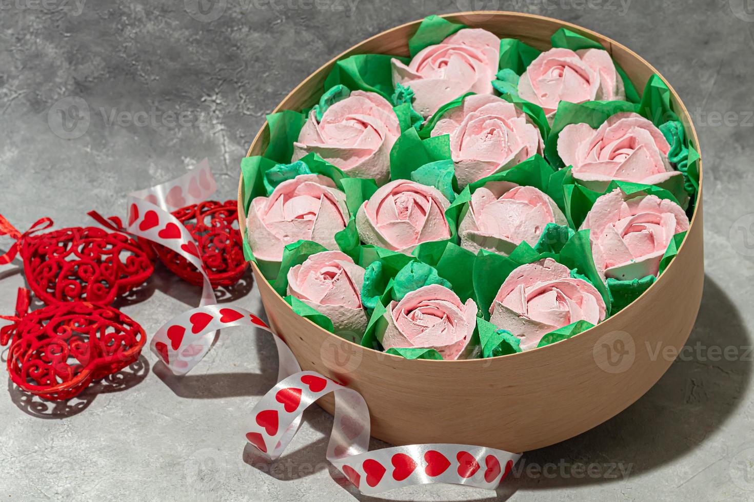 Handmade marshmallows in wooden packages on a light background with flowers. The concept of the holidays Women's Day and Valentine's Day. photo