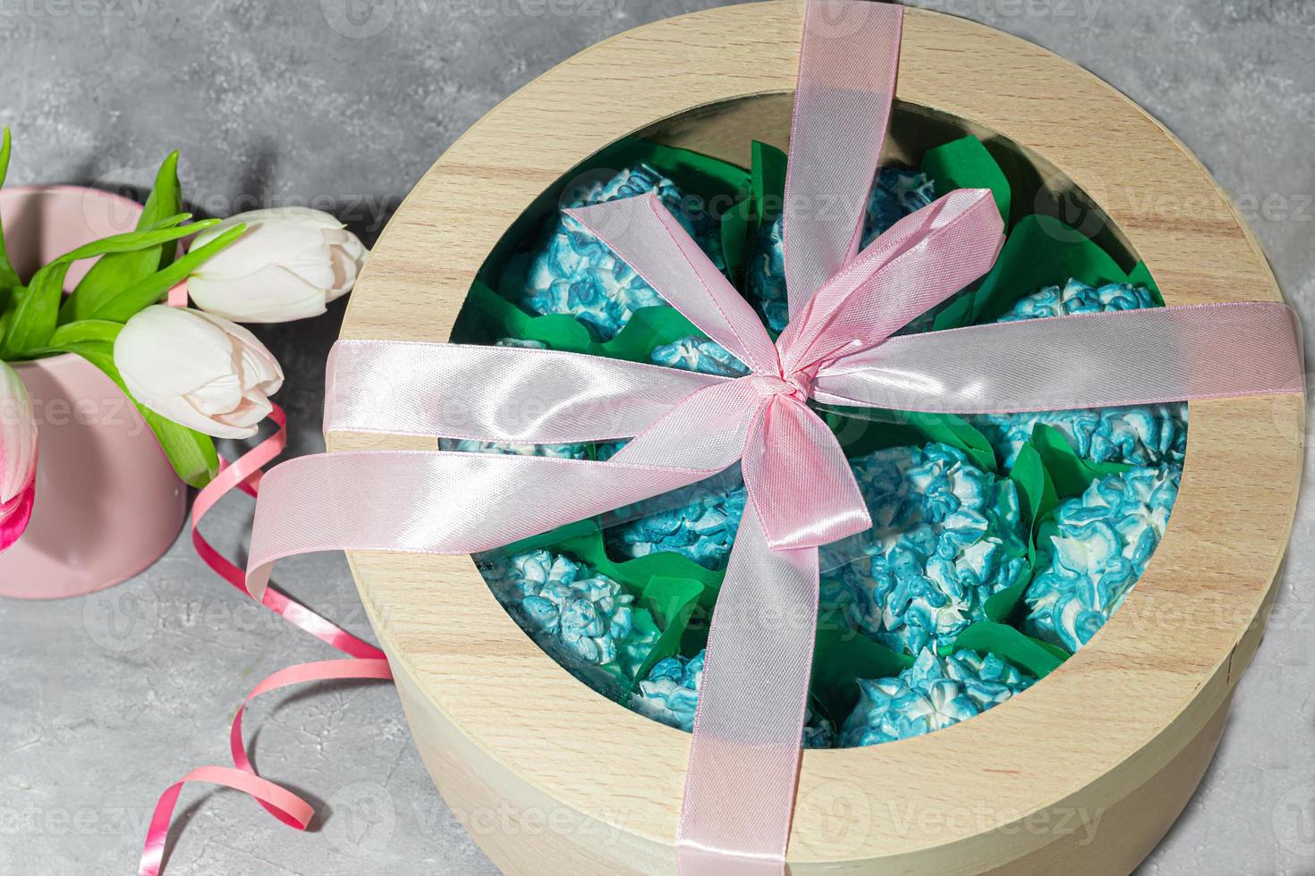 Handmade marshmallows in wooden packages on a light background with flowers. The concept of the holidays Women's Day and Valentine's Day. photo