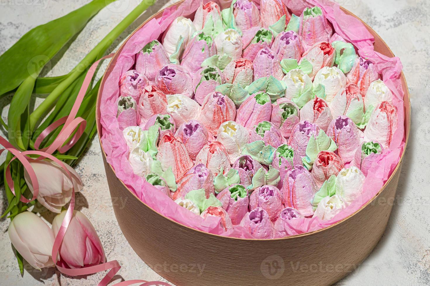 Handmade marshmallows in wooden packages on a light background with flowers. The concept of the holidays Women's Day and Valentine's Day. photo